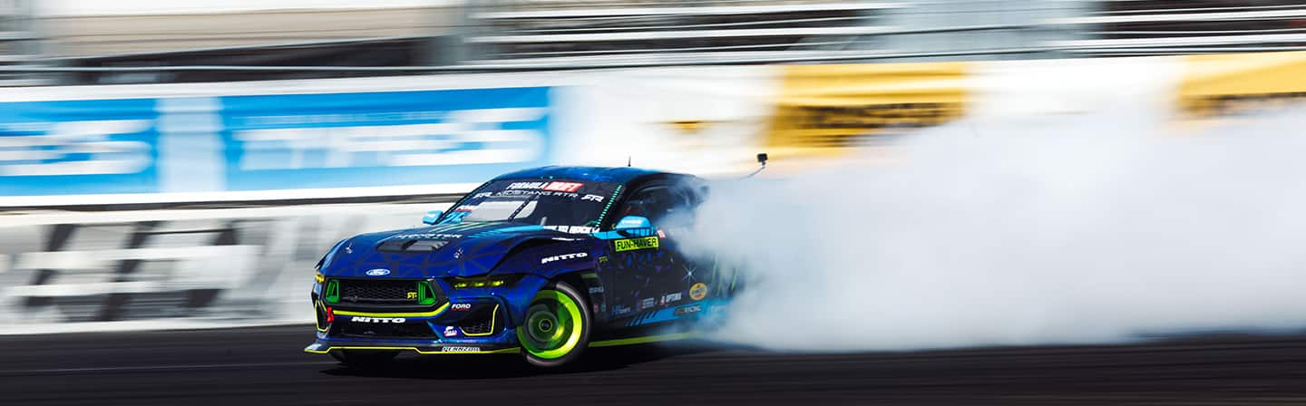 Vaughn Gittin Jr.’s blue number 25 Monster Energy Ford Mustang RTR Spec 5-FD race car on track