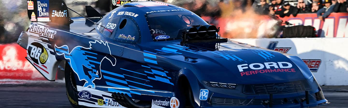 Bob Tasca III’s blue Mustang Dark Horse Funny Car race car on track