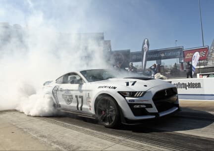 White Ford Mustang with smoke emerging from the back