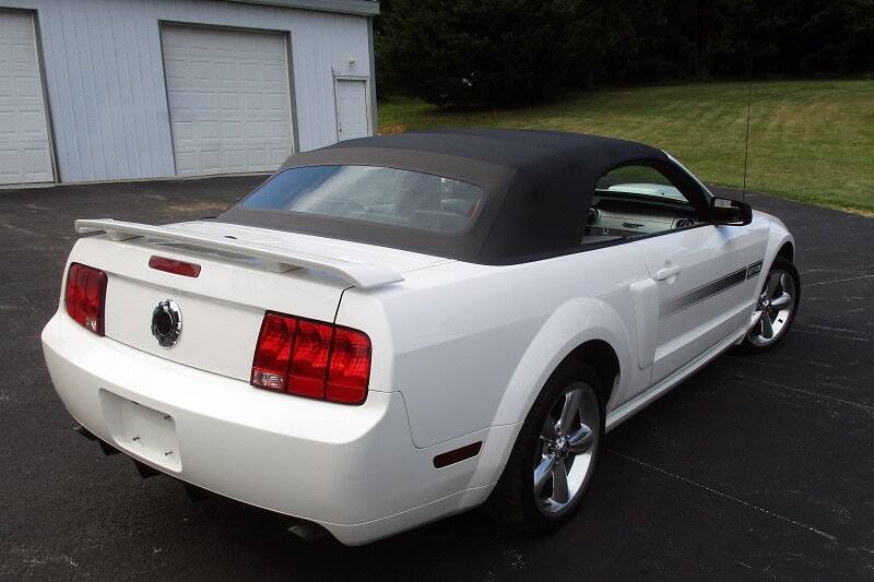 Rear view of white 2007 Mustang GT/CS parked in front of garage doors