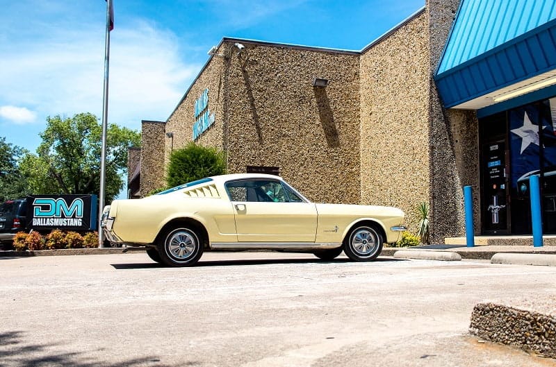 Side profile of 1966 Mustang Fastback parked outside of building