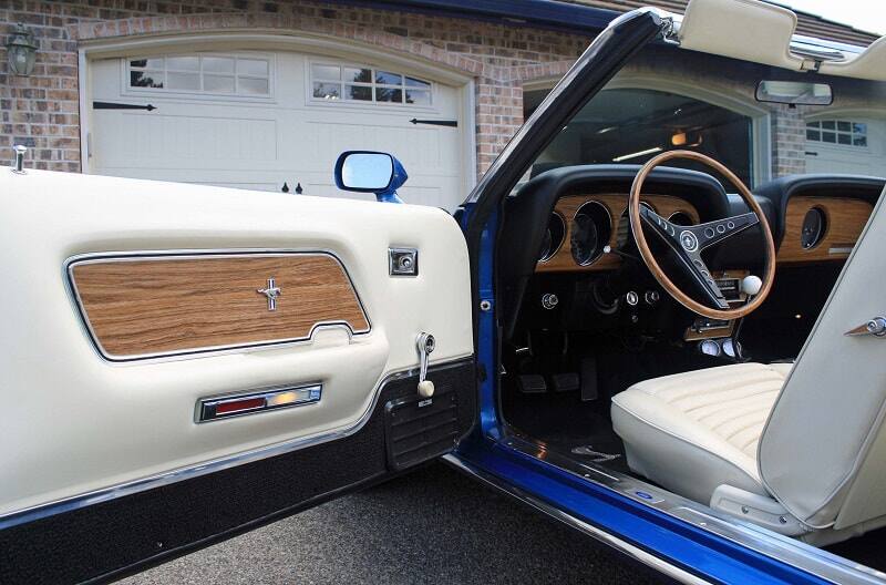 Photo of the 1969 Mustang convertible parked in front of garage with driver side door ajar