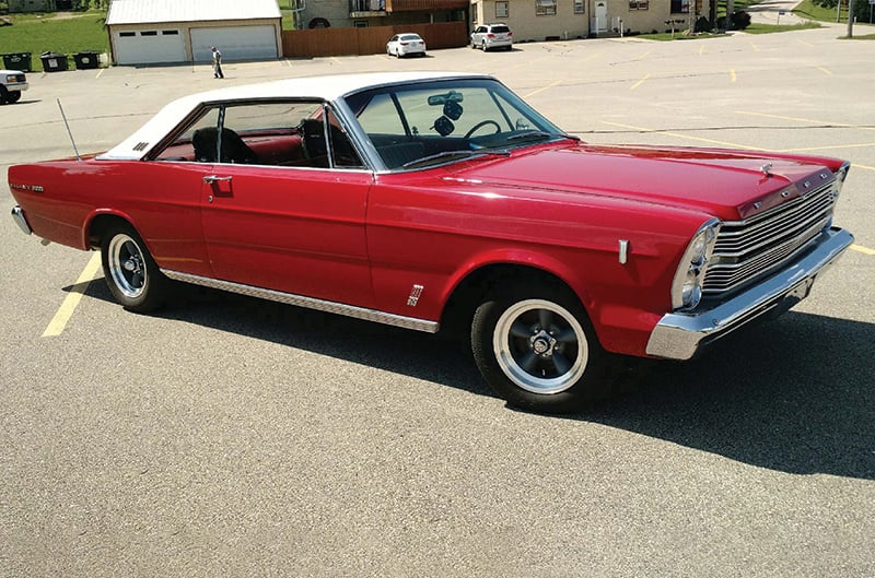 Passenger side view of red 1966 Ford Galaxie 500 with dice hanging from rear-view mirror