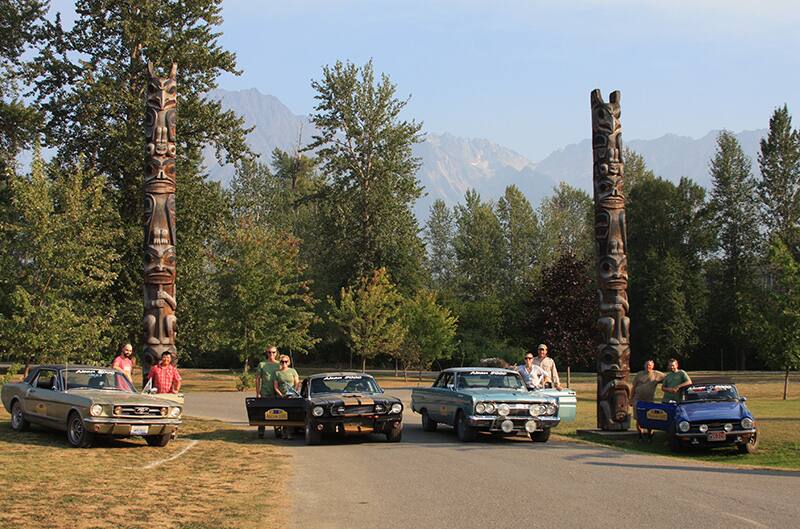 Four cars and their owners parked to pose for photo during the Alcan 5000