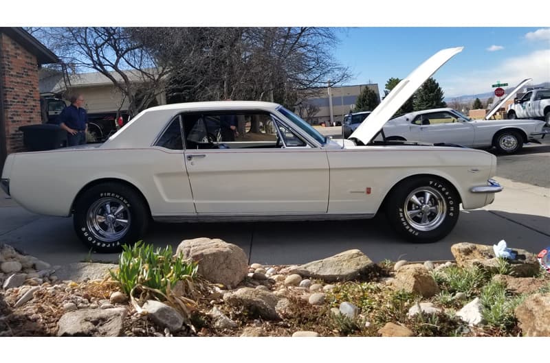 Passenger side view of Wimbledon White 1965 Mustang GT parked on a driveway with hood open