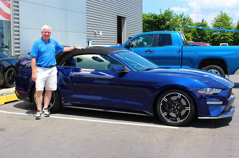 Dennis Healy posing in front of his parked Kona Blue 2019 Mustang GT CS Convertible