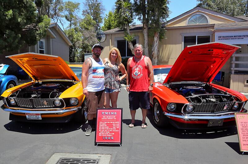 Mike Venarde and friends posed in front of twin 1969 Boss 302 Mustangs