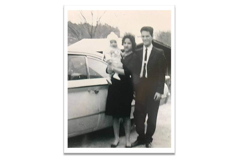 Black and white photo of Terry's parents holding him as a baby