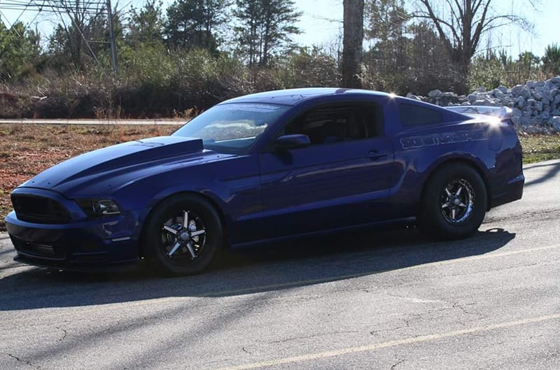 Profile of blue Mustang on the road