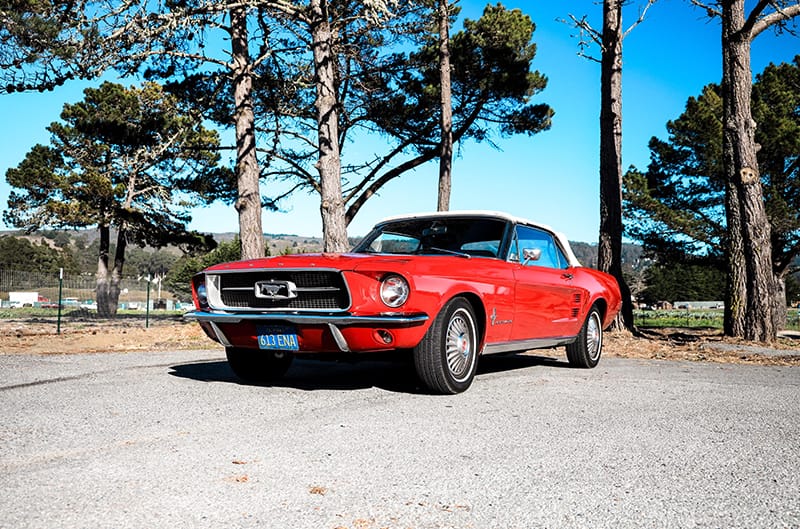 Front profile of the red Mustang in a parking lot