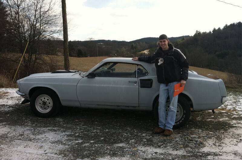 Brian posing next to gray Mach 1 on snow covered grass