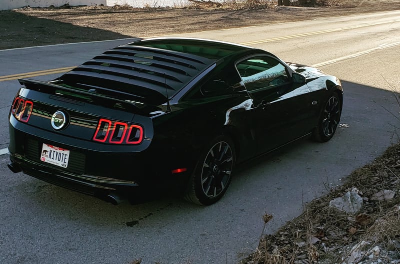 Rear profile of black Mustang GT on the road