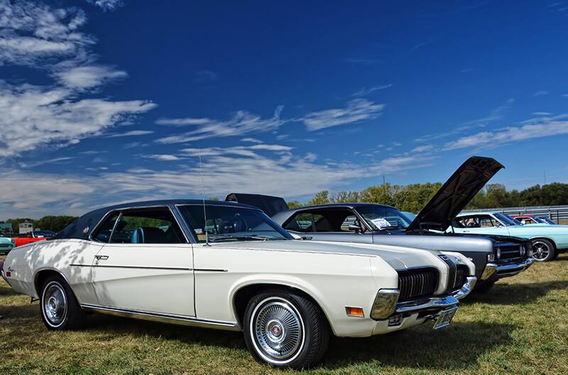 White Cougar at car show with blue sky