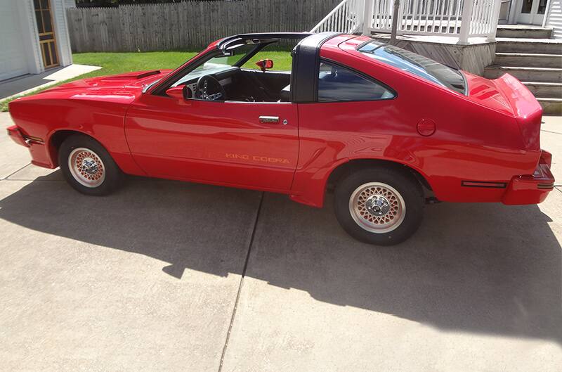 Drivers side of mustang II in driveway sunny day