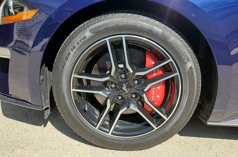 Photo of driverside front wheel with red brake caliper cover