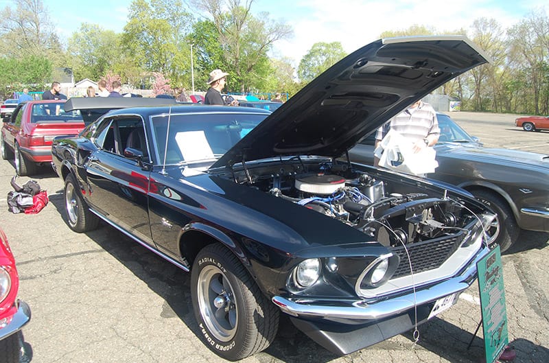 Black 1969 Mustang in Black with hood raised at Car show