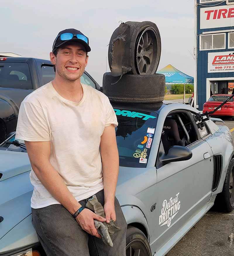Brandon Barry standing with his Mustang at Gridlife