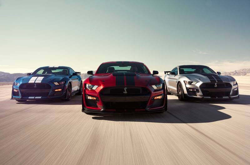 The front end of blue, red and grey Mustangs