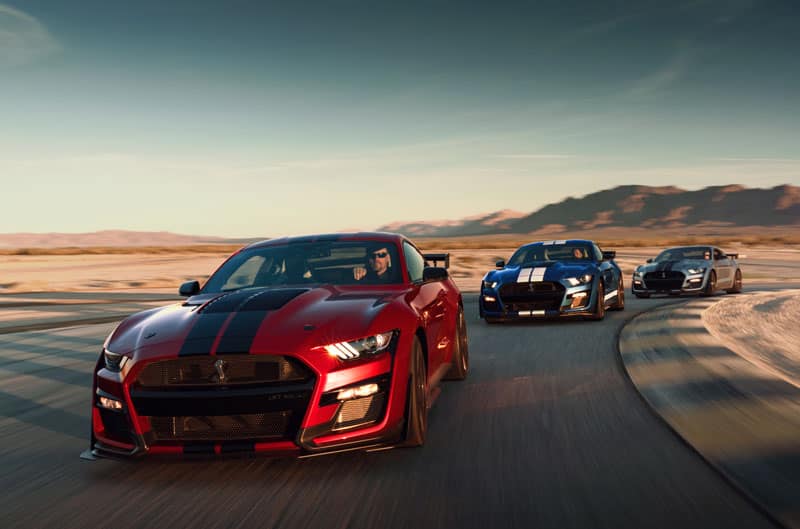 Three Mustangs making a left turn in a line