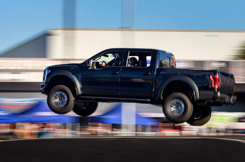 A black Ford truck gliding through the air