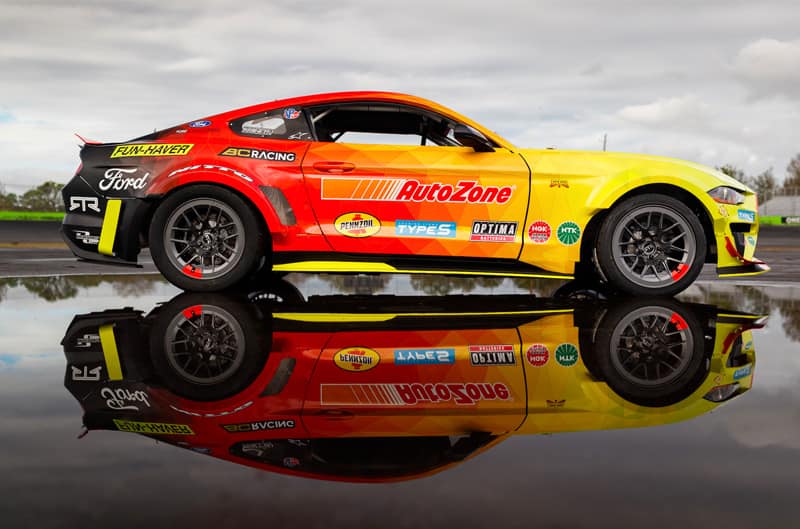 Adam LZ's Orange and Yellow Mustang with side reflection in puddle