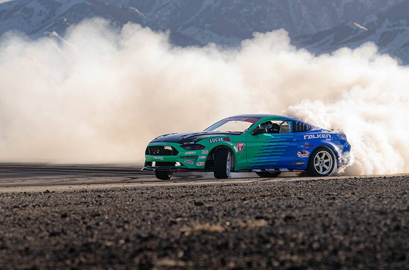 Mustang drifting with mountains in background