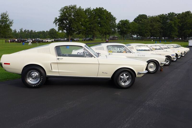 A side view of a lineup of white Ford Mustang Cobra Jets on display