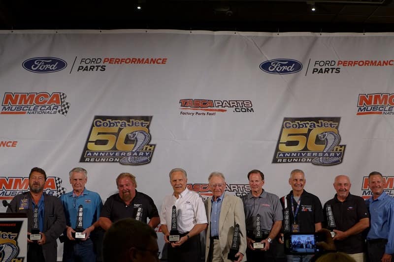 A lineup of men holding awards at the reunion