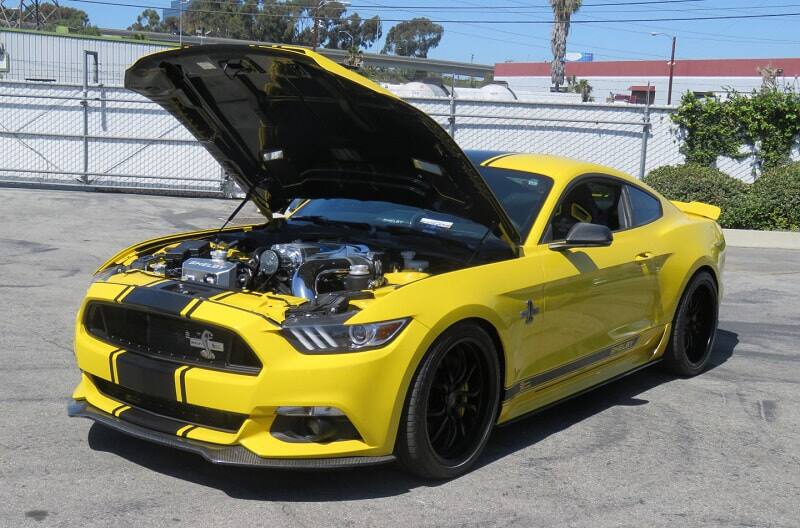 A yellow Shelby Mustang on display with the hood up