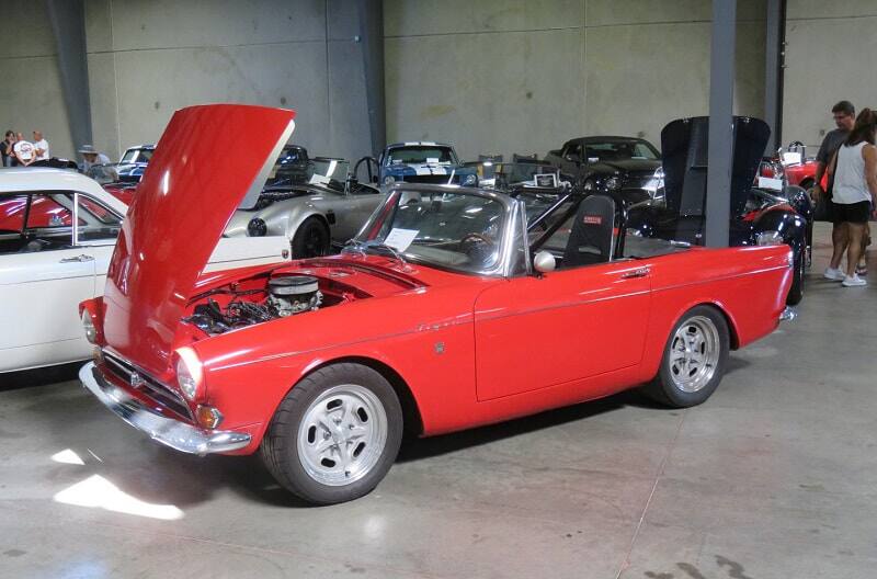 A side view of a classic red convertible on display