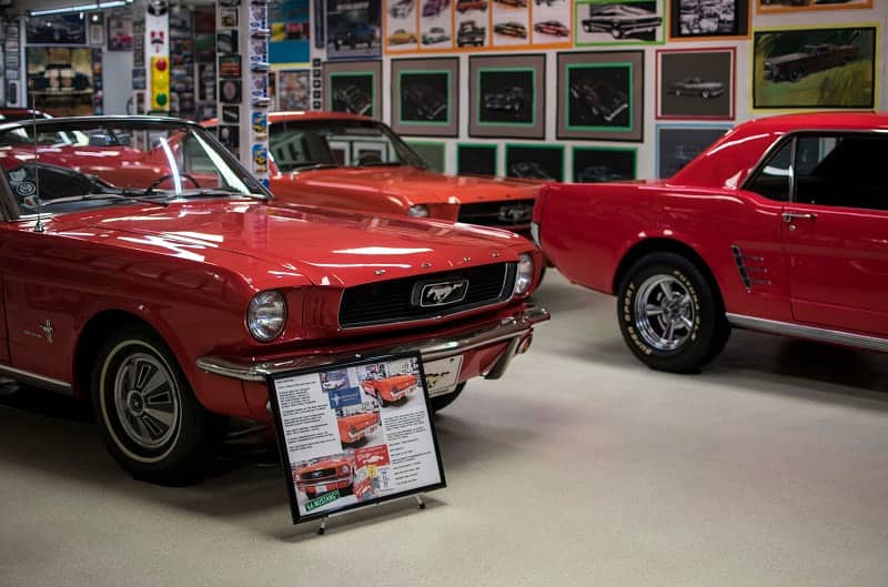 A room with classic red Mustangs inside at the museum