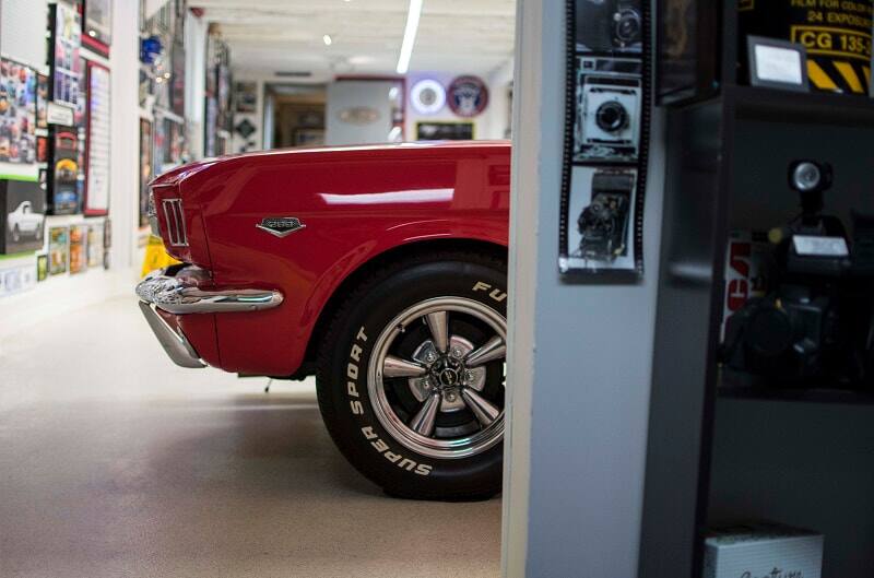 A side view of the left front quarter panel of a red Ford Mustang