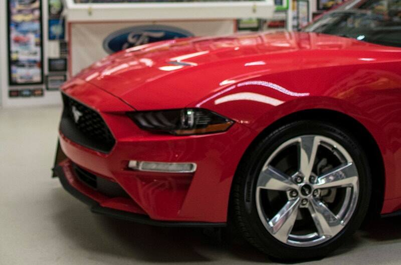 A side view of the front end of a red Mustang