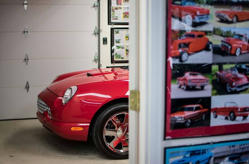 A side view of the front end of a classic red vehicle on display