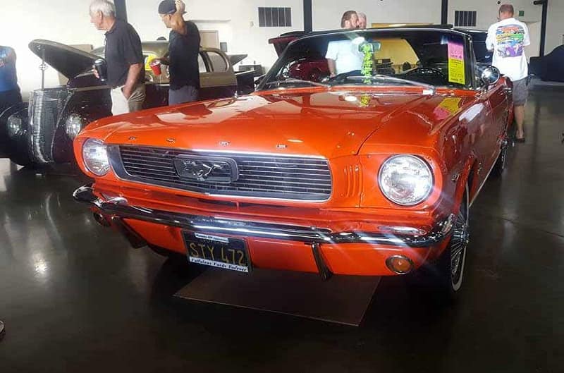 A front end view of a classic red Mustang on display