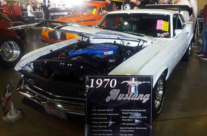 A front side view of a classic white Mustang on display