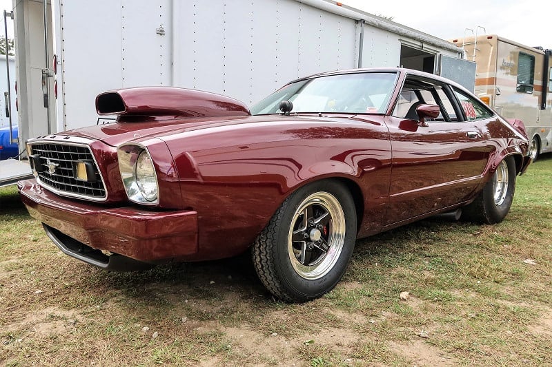 A front side view of a maroon Mustang