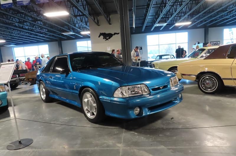 Front of a blue Shelby Mustang parked in garage on display