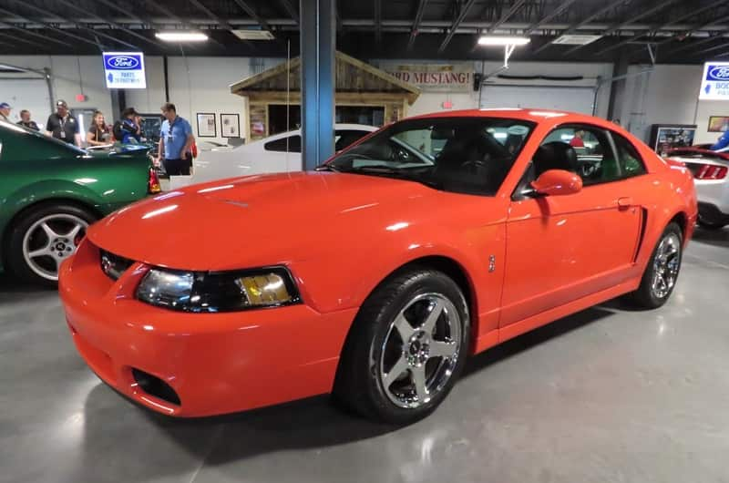 Front profile of orange Shelby Mustang parked in garage