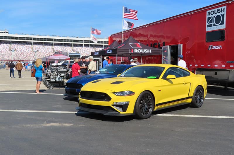 A front side view of a yellow Ford Mustang on display