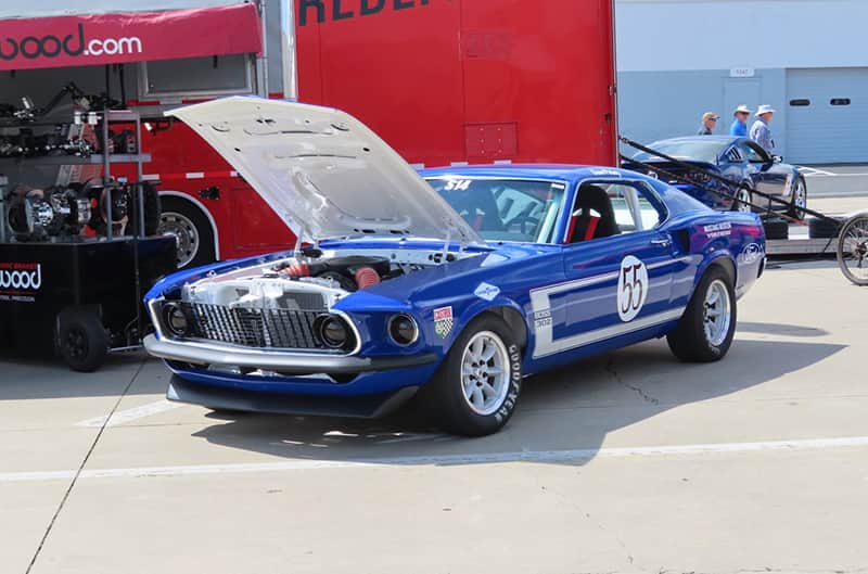 A classic blue Mustang on display with the number 55 on the side
