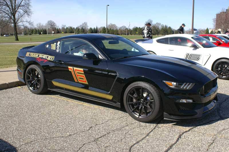 A black Shelby Mustang on display with the number 16 on the side