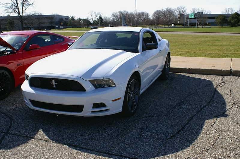A front side view of a white Mustang on display
