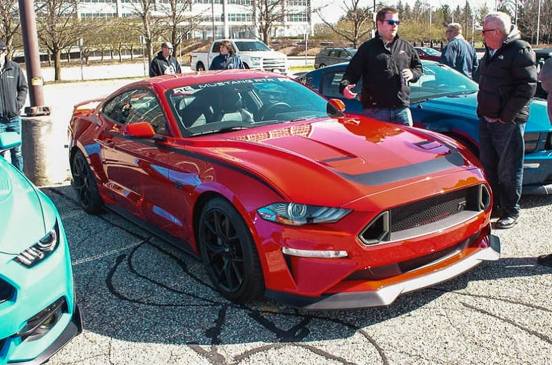A front side view of a red Mustang on display