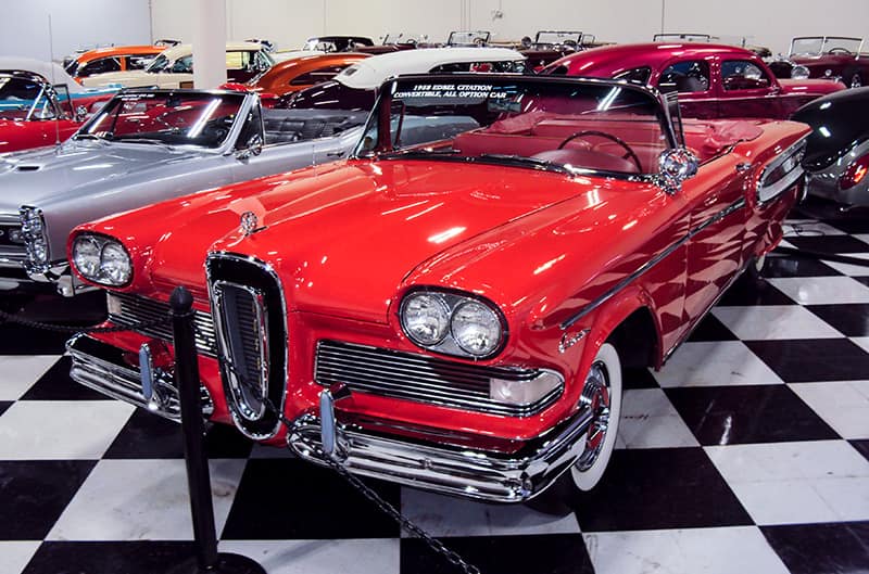 A front side view of a classic red vehicle on display