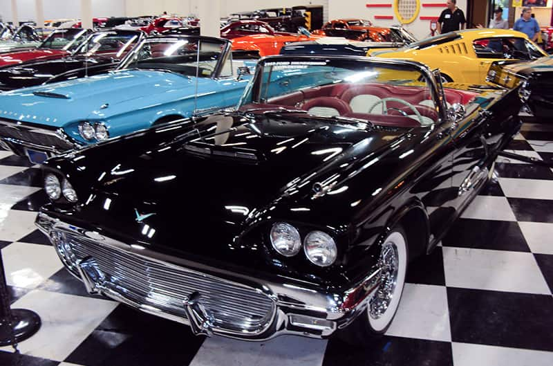 A front side view of a classic black vehicle on display at the museum