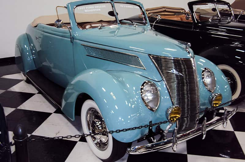 A classic light blue Ford Deluxe Roadster on display