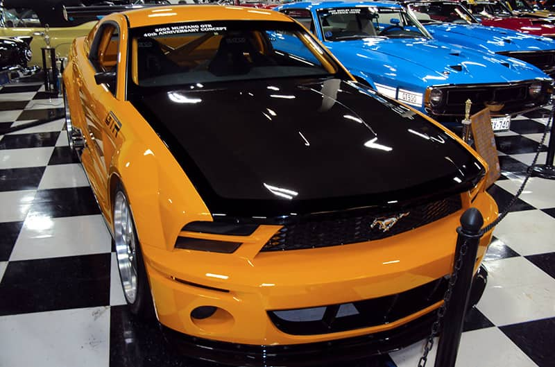 An orange and black Mustang on display