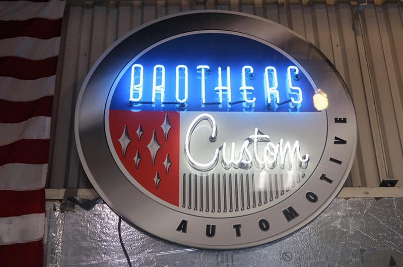 Lit up Brothers Custom Automotive sign on the wall