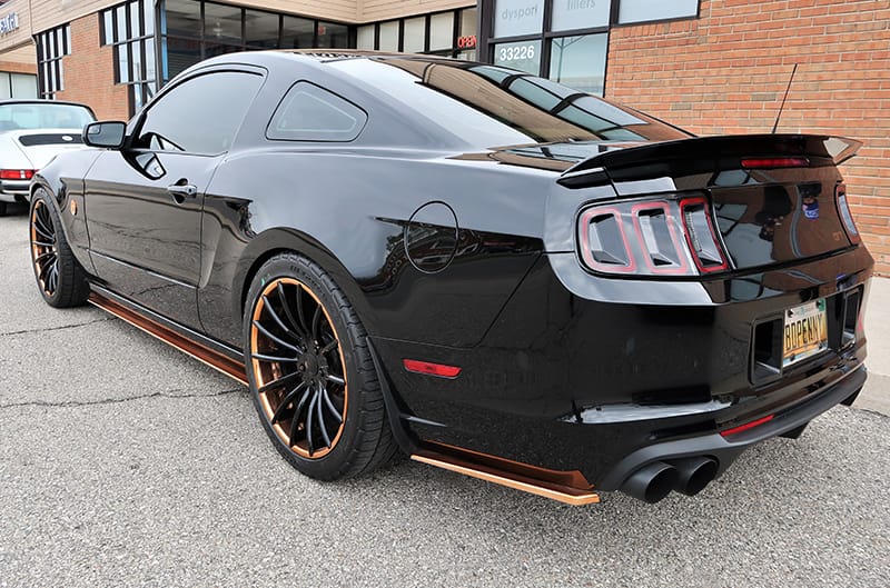 Rear profile of a black Mustang GT in parking lot